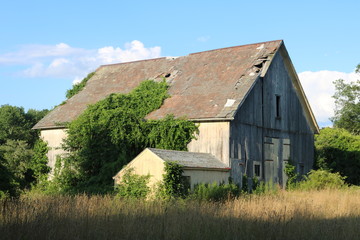 Obraz premium Old abandoned historic farmhouse with broken windows and peeling paint