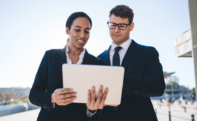 Smiling business coworkers using tablet