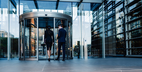 Formal colleagues entering office building - Powered by Adobe