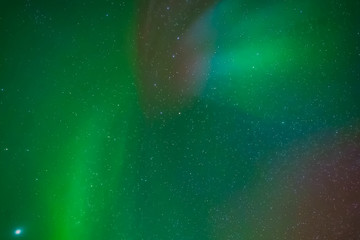 Aurora borealis in night northern sky. Ionization of air particles in the upper atmosphere.