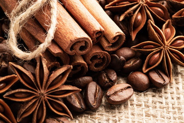 Cinnamon and anise on the background of coffee beans and burlap.