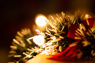 Christmas background out of focus. Candle, tinsel and bow blurred.