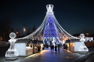 Christmas tree decorated with white and blue lights for Christmas 2019 and New Year 2020, market...