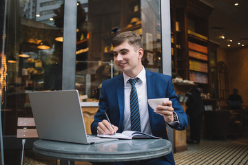 Young male working on laptop in cafe