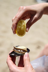 stuffed mussels and woman squeeze lemon. midye dolma in Turkish language