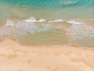 Fototapeta na wymiar Amazing Beach and waves from top view. Turquoise water background from top view. Summer seascape from air. Top view from drone. Travel concept and idea. North Cyprus, Golden Beach, Karpaz.