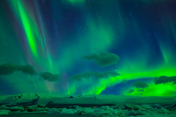 Aurora borealis in night northern sky. Ionization of air particles in the upper atmosphere.