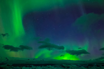 Aurora borealis in night northern sky. Ionization of air particles in the upper atmosphere.