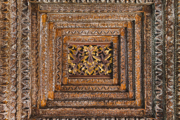 Handmade wooden ceiling roof in balinese style with flowers and birds ornament. Seamless ornament. Handicraft wood carving, local indonesian tradition.