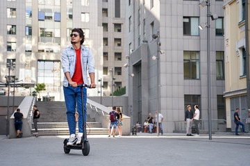 Young adult guy ride on electric scooter © Viktoriia