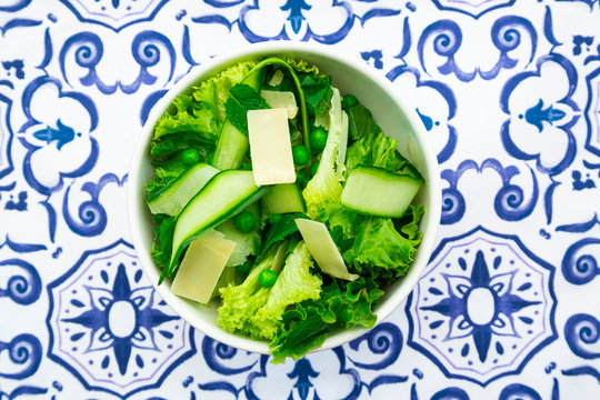 Overhead view of pea and cucumber salad on patterned table