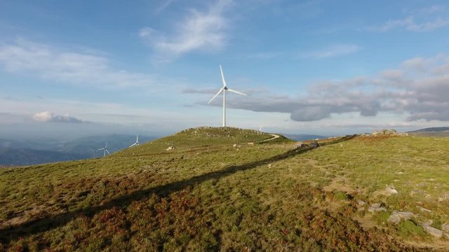 eolic turbine wind renewable energy farm on top of mountain aerial shot 