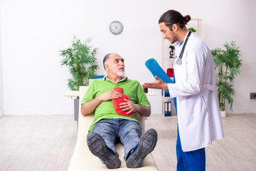 Old man visiting young male doctor gastroenterologist