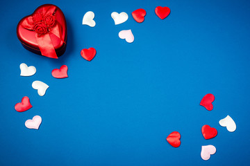 Red heart with a gift to Valentine's Day on a beautiful blue background. Heart pendant. Space for...