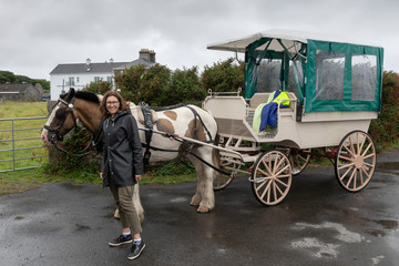 Woman standing near horse carriage, Galway City, County Galway, Ireland