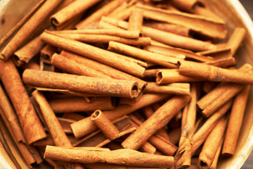 Cinnamon sticks in ceramic bowl, close-up, food background