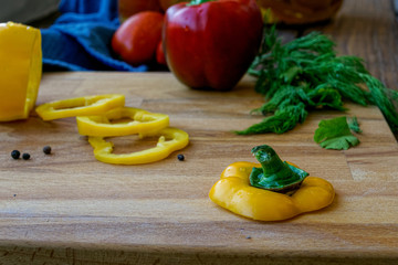 sliced bell peppers on wooden background