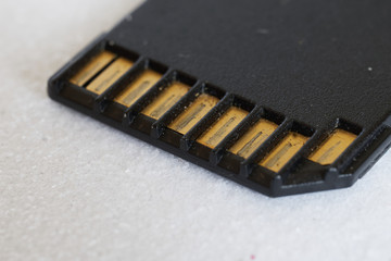 Worn, scratched and dusty metal contacts of a memory card lying on a light background