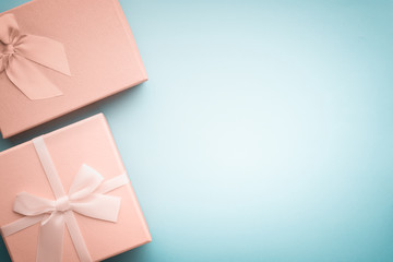 Top view beige gift boxes with ribbons tied with a bow on a light blue background in pastel colors