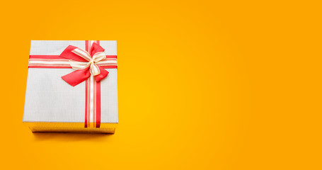 Christmas gift box on yellow background banner with copy space