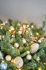 Big arrangement of fresh spruce in a wicker basket. Decorated with blue balls, cones and small stars. Christmas mood. light bulbs Garlands