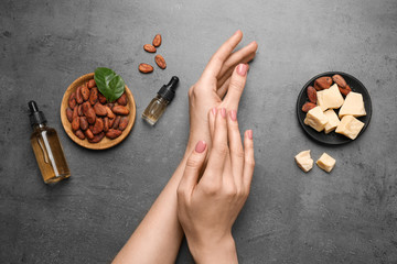 Woman applying organic cocoa butter at table, top view