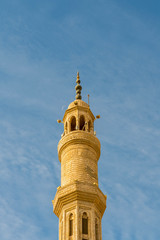 Fototapeta na wymiar Minaret on a background of blue sky. Islamic faith concept. vertical photo