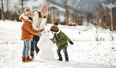 Foto auf Leinwand happy family mother and children having fun on winter walk © JenkoAtaman