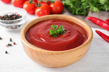 Delicious tomato sauce on white wooden table, closeup