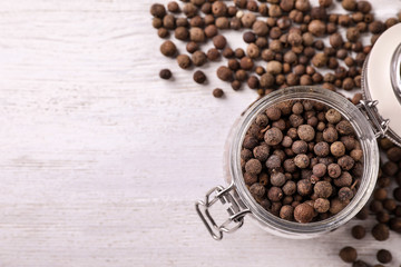 Black pepper grains on white wooden table, flat lay. Space for text