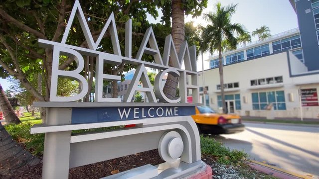 An establishing shot view of the famous Welcome to Miami Beach sign on 5th Street.  	