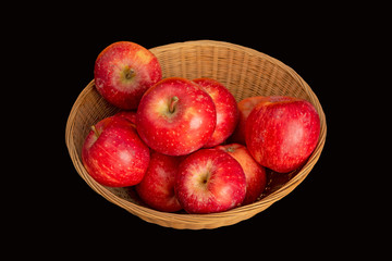 Fresh red apples in basket on black background with copy space