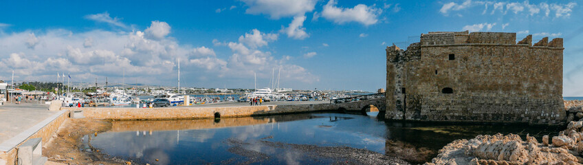 Fototapeta premium Ancient Paphos castle or fortress - now museum and harbour with boats and yachts panorama. Cyprus mediterranean travel concept.
