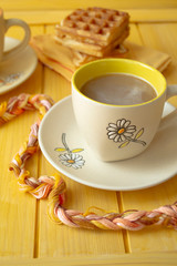 Yellow color of conceptual image of happy morning, hot cocoa or chocolate on wooden table, vertical image