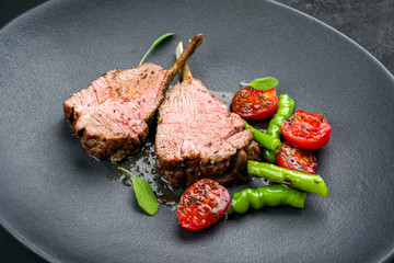 Barbecue rack of lamb neck with paprika and tomato offered as closeup on a modern design plate