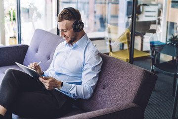 Happy man chilling in office and listening music