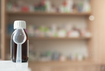 medicine in a vial with a measuring spoon