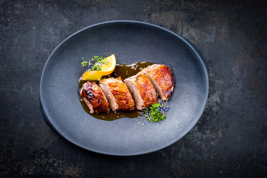 Traditional Roasted Christmas Duck Breast With Orange Slice And Herbs As Top View On A Modern Design Plate