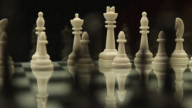 change of focus of the camera on a chessboard with white and black chess pieces on a black background