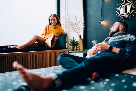 Young Couple Talking In Decorated Bedroom