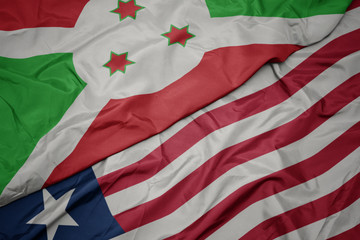 waving colorful flag of liberia and national flag of burundi .