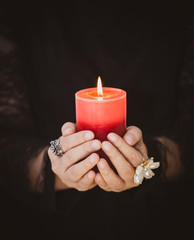 A picture of a woman holding a candle to perform magic rituals and mysteries about superstition in...