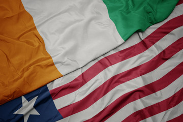 waving colorful flag of liberia and national flag of cote divoire.