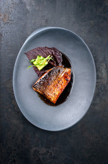Japanisch minimalistic Design Lachs Fischfilet mit Gemüse und Nori Algenblätter in Teriyaki Sauce als Draufsicht auf einem Modern Design Teller