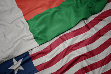 waving colorful flag of liberia and national flag of madagascar.