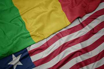waving colorful flag of liberia and national flag of mali.