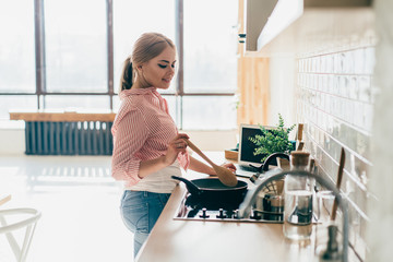 Young woman cooking standing in kitchen