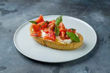 bruschetta with tomatoes and cheese on grey table