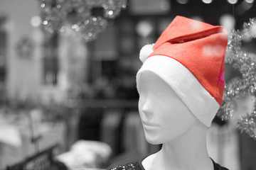 A mannequin on a display case with a red cap on his head. The concept of the New Year's sale.
