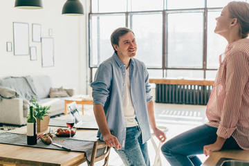 Obraz premium Smiling young couple in kitchen looking at each other
